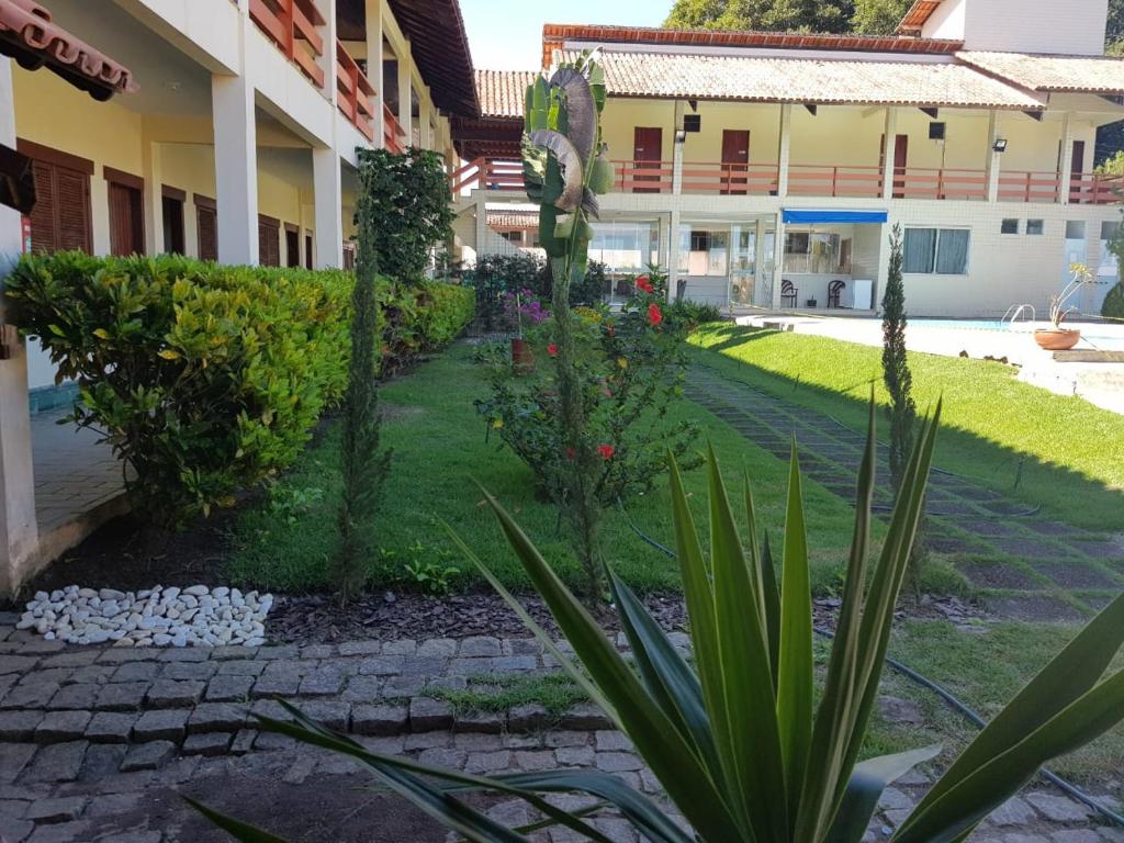 einen Garten vor einem Gebäude mit Pflanzen in der Unterkunft Marinas Pousada in Pasto da Mata