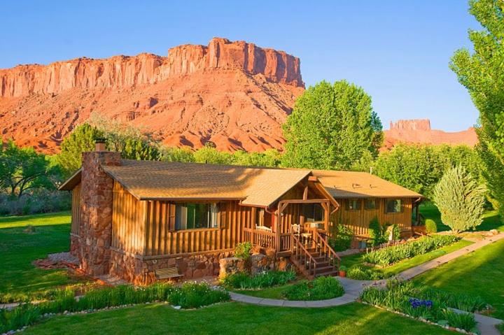 a log cabin with a mountain in the background at Castle Valley Inn in Moab
