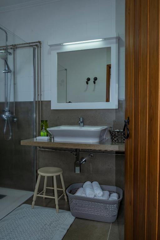 a bathroom with a sink and a stool and a mirror at Casa da Quinta in Vila Franca do Campo
