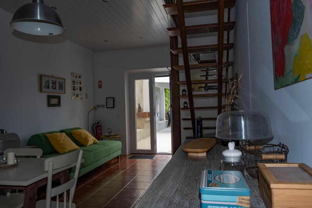 a living room with a green couch and a staircase at Casa da Quinta in Vila Franca do Campo