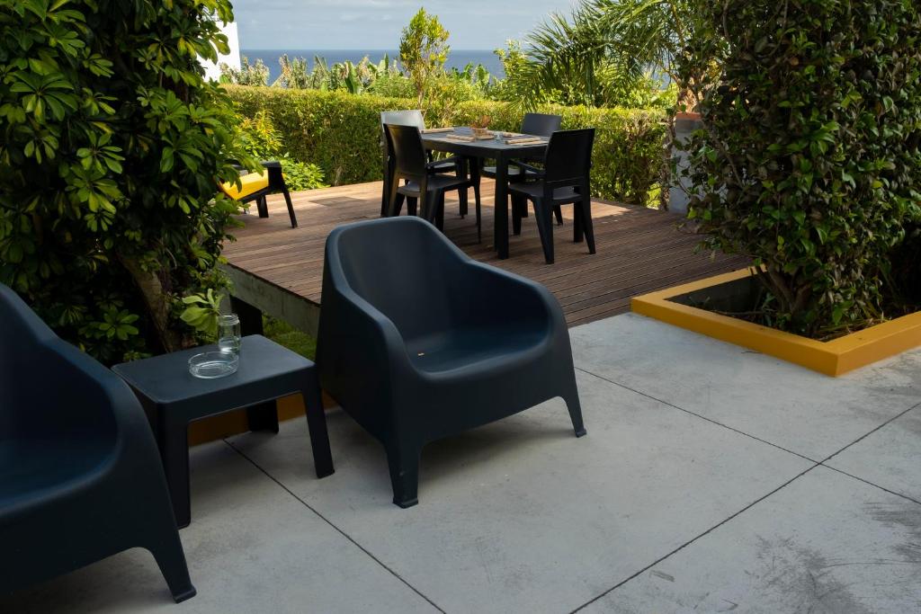 a wooden deck with chairs and a table and chairs at Casa da Quinta in Vila Franca do Campo