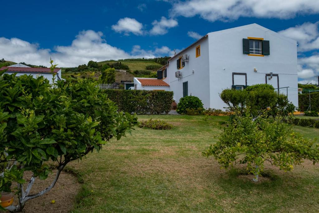 a white house with trees in front of it at Casa da Quinta in Vila Franca do Campo
