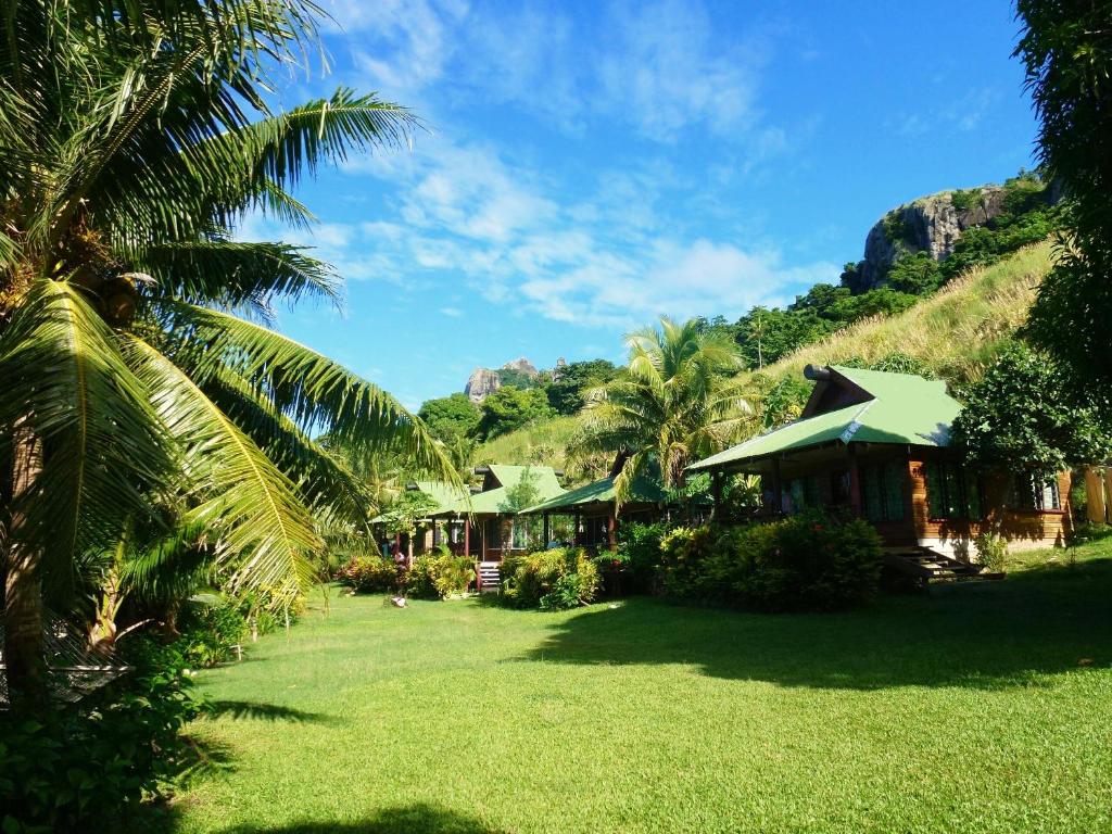 a resort with palm trees and a grass yard at Naqalia Lodge in Wayasewa Island