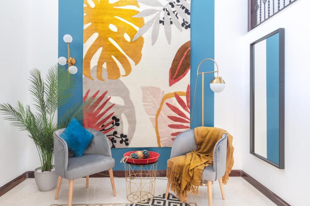 a living room with two chairs and a mural at Stella Stays Exceptional 4 BDR Palm Villa Beach Private Pool in Dubai