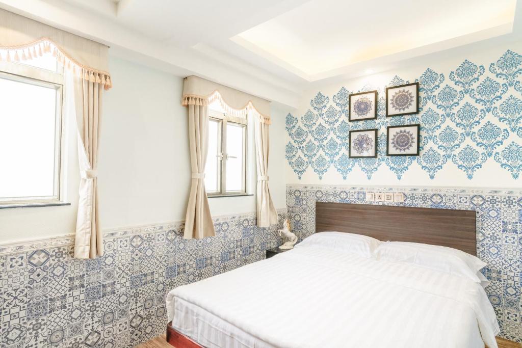 ein Schlafzimmer mit blau und weiß gefliesten Wänden und einem Bett in der Unterkunft Hou Kong Hotel in Macau