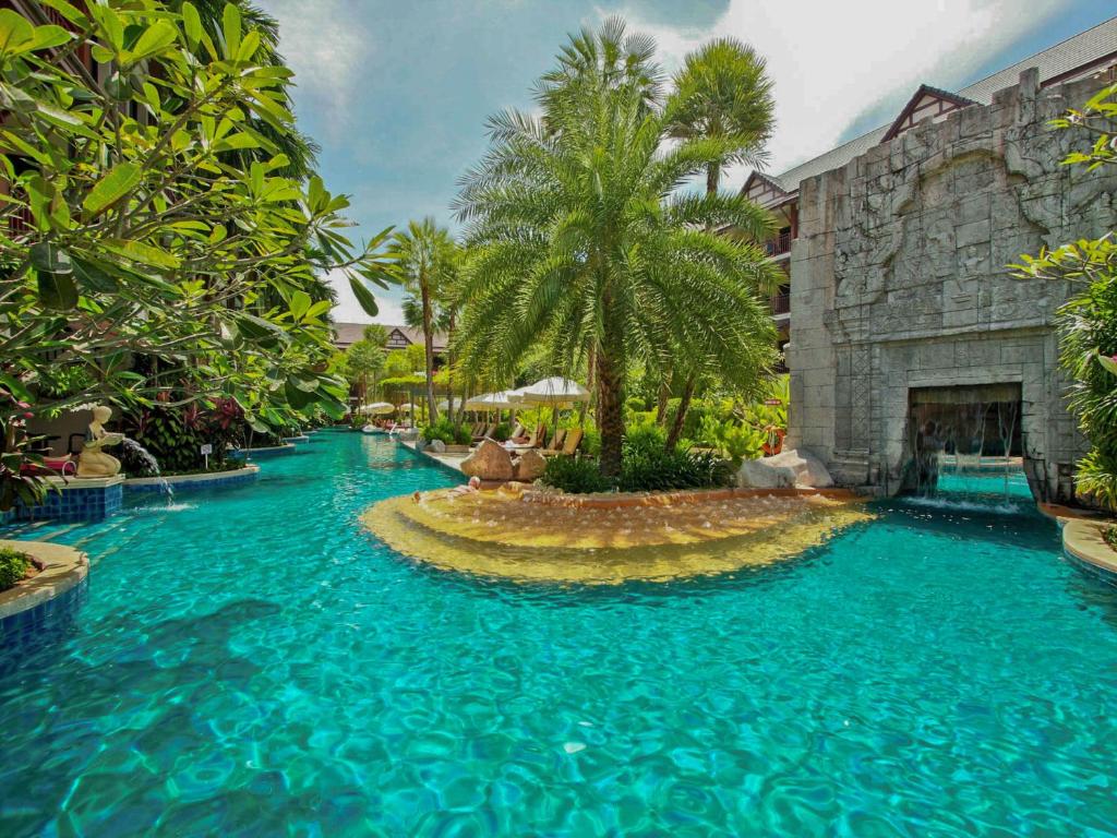 a large pool with blue water in a resort at Kata Palm Resort - SHA Plus in Kata Beach