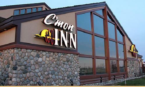 a front of a building with a sign on it at C'mon Inn & Suites Fargo in Fargo