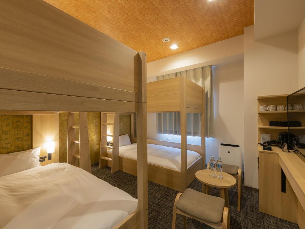Tosei Hotel Cocone Asakusa Kuramae في طوكيو: غرفة في الفندق مع سرير وسرير بطابقين