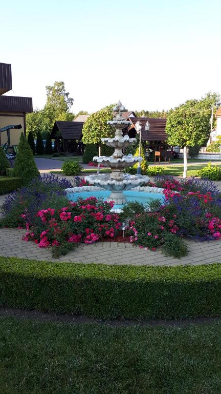 a garden with a fountain and flowers in a park at Astra-Poilsis Sventojoje in Šventoji