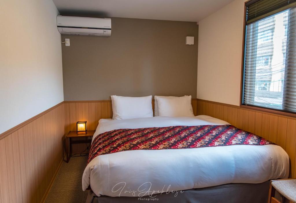 um quarto com uma cama grande e uma janela em Hotel Sou Kyoto Gion em Quioto