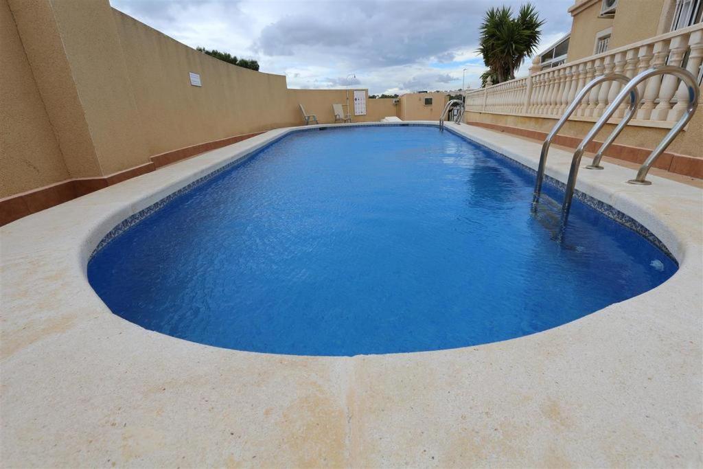 una gran piscina azul en un edificio en Maison de vacances de 3 chambres à Orihuela Costa - Torrevieja !, en Orihuela