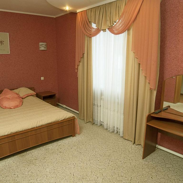 a bedroom with a bed and a large window at Готельний комплекс Самікс in Kyiv
