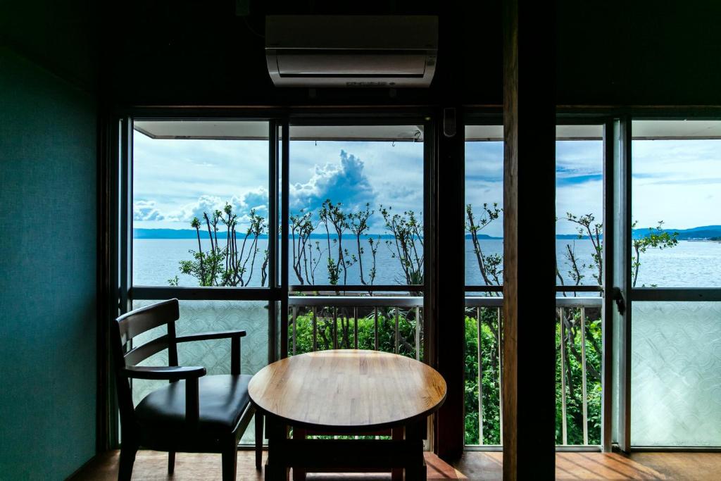 a table and chairs in front of a large window at Saitosyukuba in Sonogi