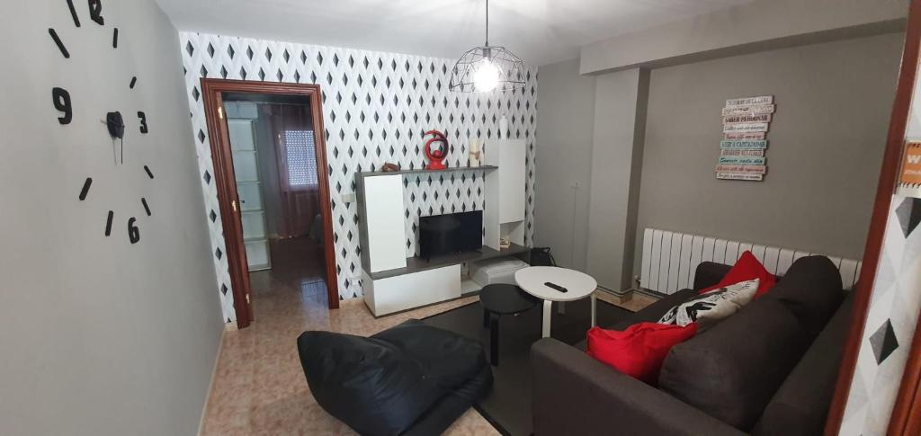 sala de estar con sofá y TV en Apartamentos Portolux, en Portomarín