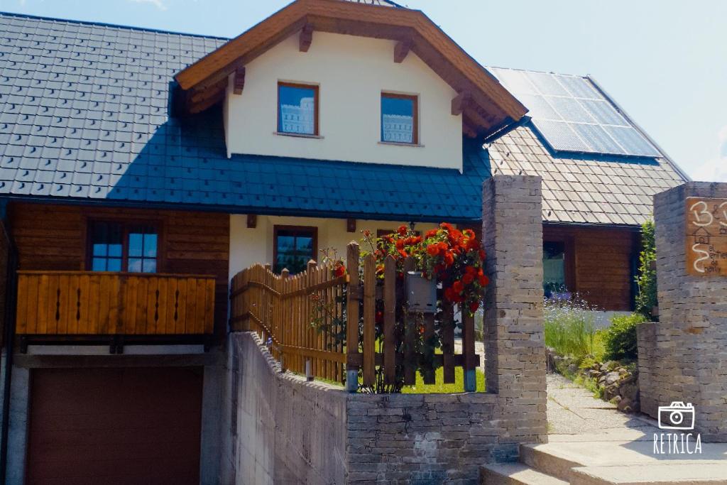 a house with a wooden gate and a fence at Al sentiero di Charly in Tarvisio