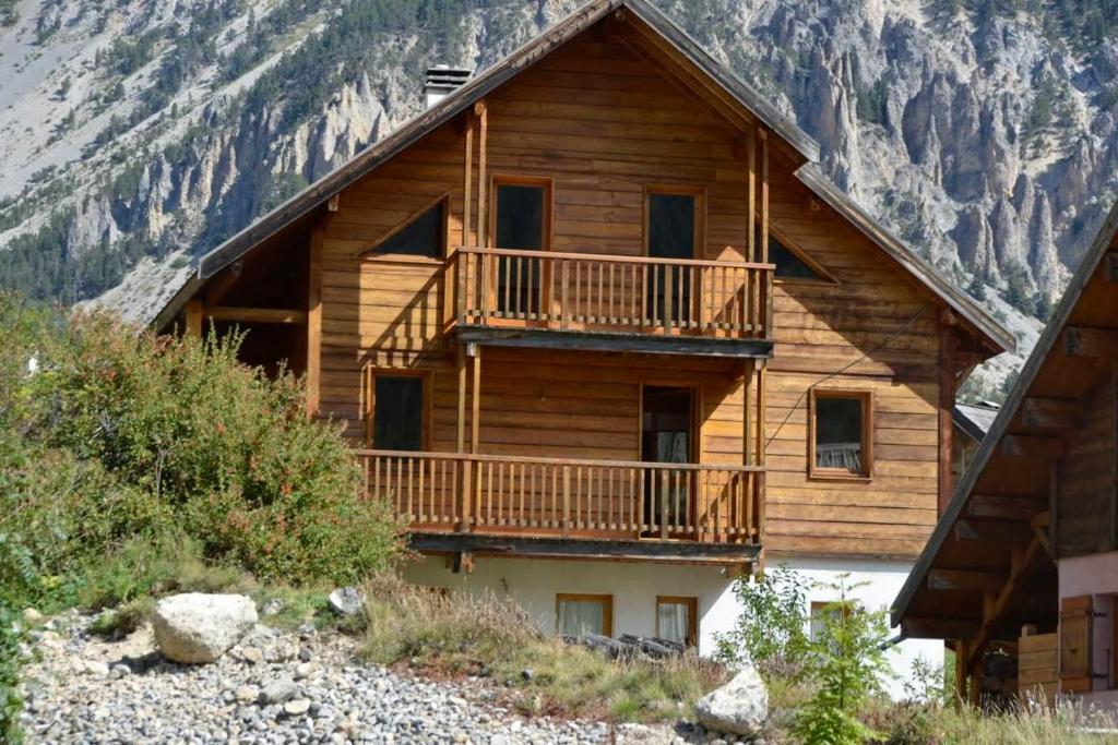 Cabaña de madera con balcón en una montaña en Chalet Le Murè hameau des Chazals Nevache Hautes Alpes en Névache