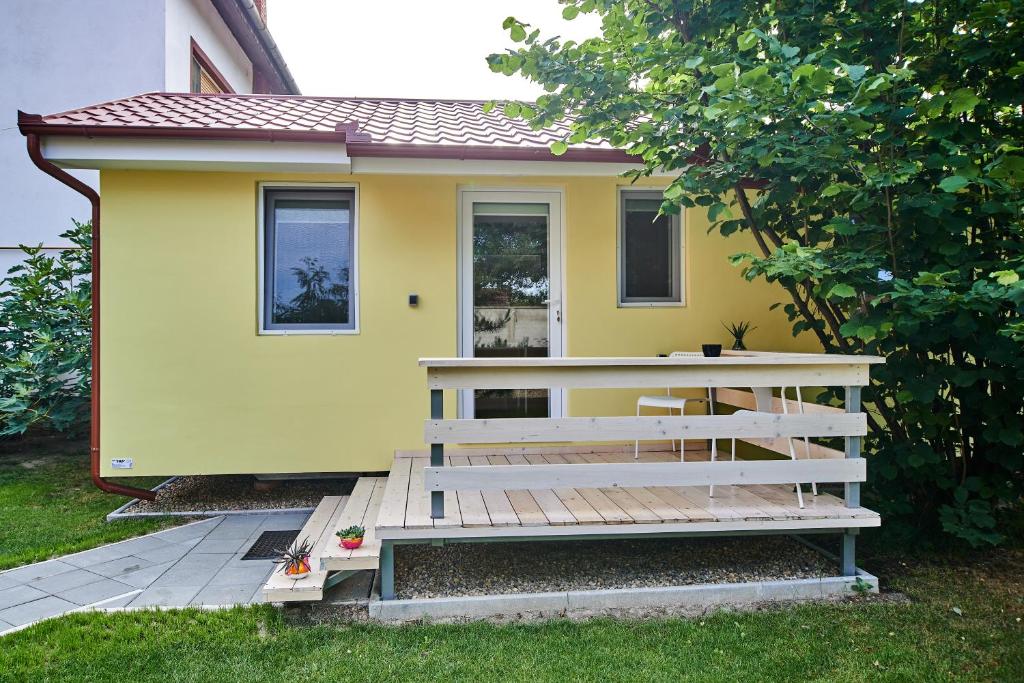 a yellow house with a wooden ramp in front of it at Ana Guesthouse in Senta