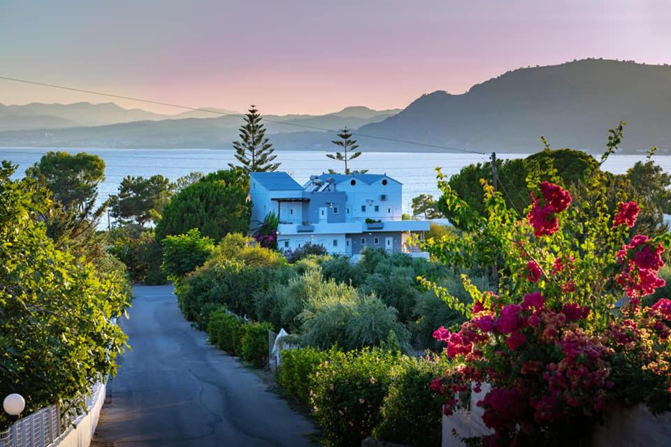 una casa en medio de un jardín con flores en George Beach Studios, en Pefki