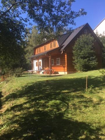 ドルニー・モラヴァにあるApartmány Dolní Moravaの草の庭に建つ大きな木造家屋