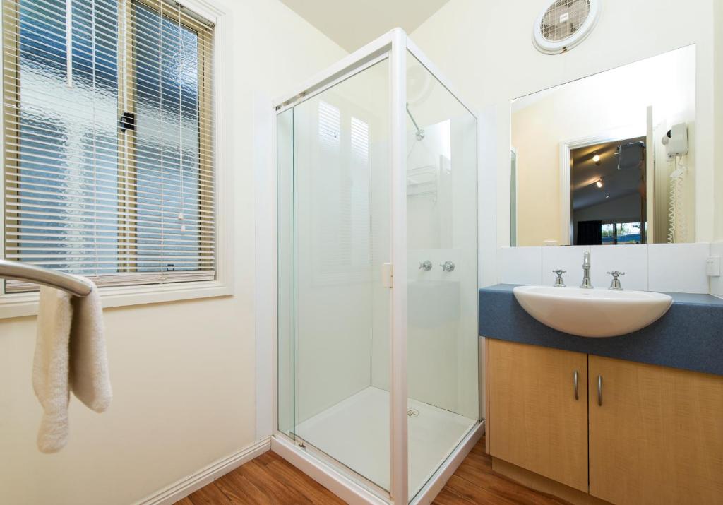 a bathroom with a sink and a glass shower at Ingenia Holidays Torquay Australia in Torquay