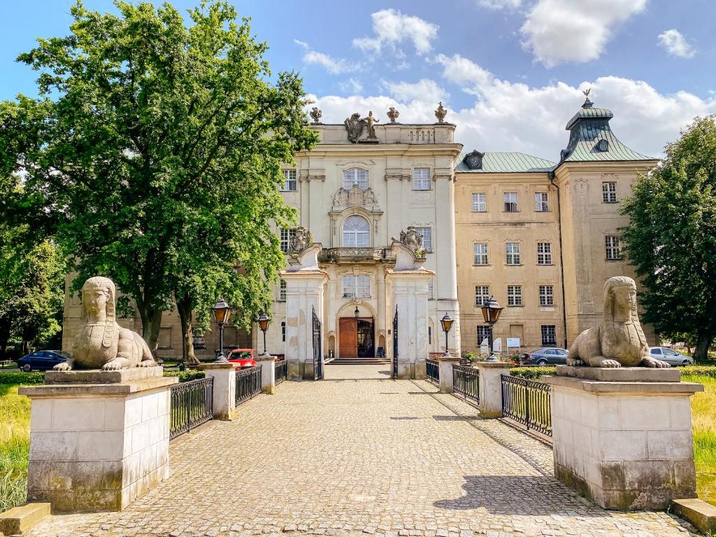 budynek z dwoma posągami lwów przed nim w obiekcie Hotel Zamek Królewski w Rydzynie w mieście Rydzyna
