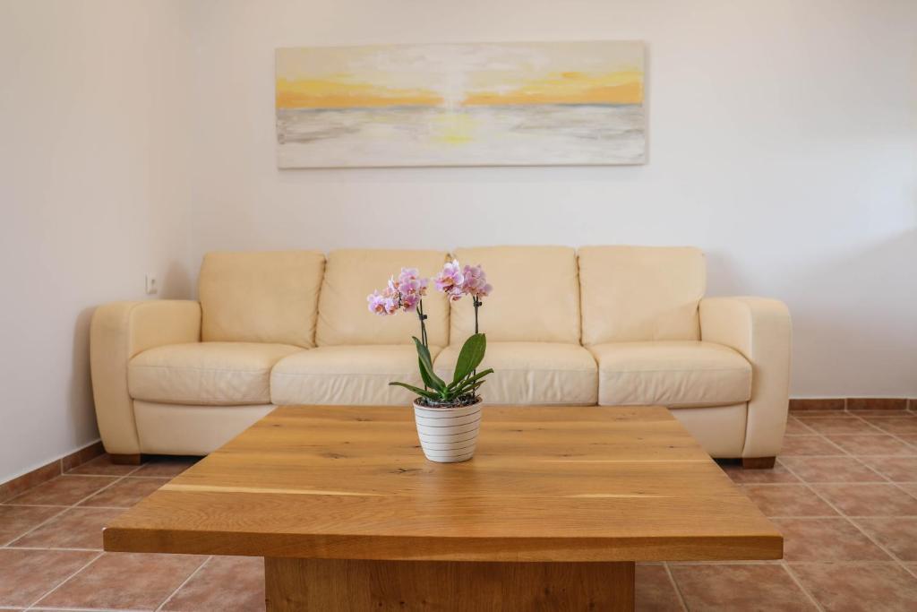a coffee table with a vase of flowers on it at Georgia Villas in Skiathos