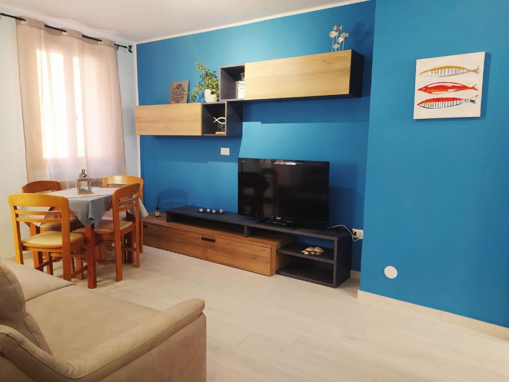 ein Wohnzimmer mit einem Sofa, einem TV und einem Tisch in der Unterkunft La casa del pesciolino (into the lagoon) - The little fish house (into the lagoon) in Chioggia