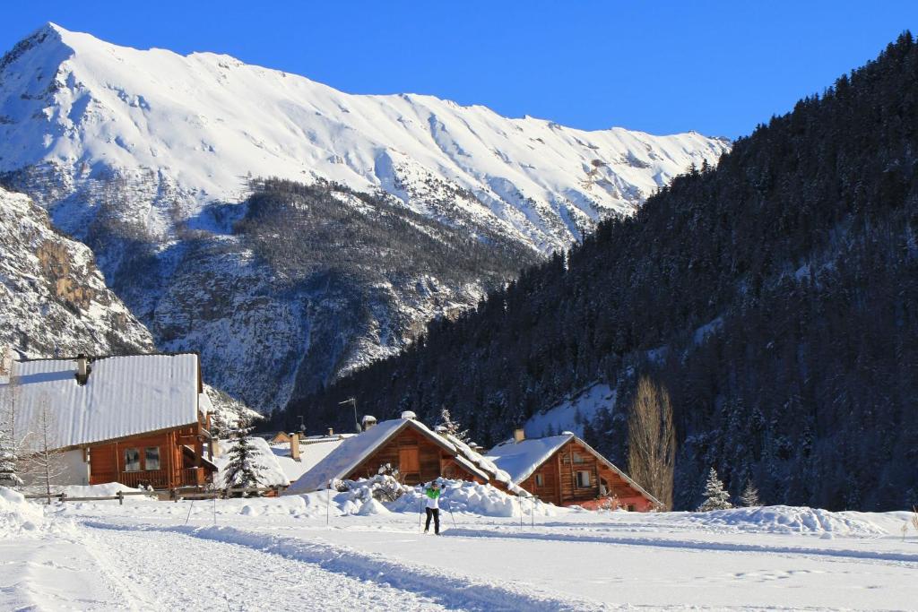 een persoon op ski's in de sneeuw voor een berg bij Chalet Le Mélézin hameau des Chazals Nevache Hautes Alpes in Névache