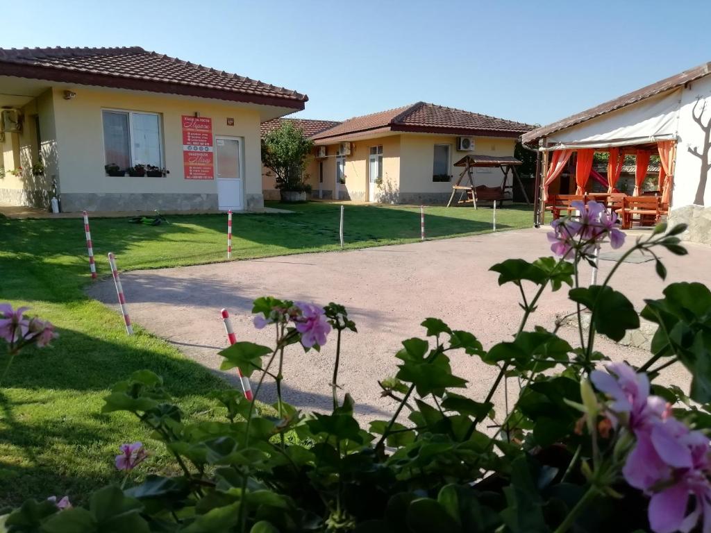 una casa con flores púrpuras en el patio en Guesthouse Mirage, en Shabla