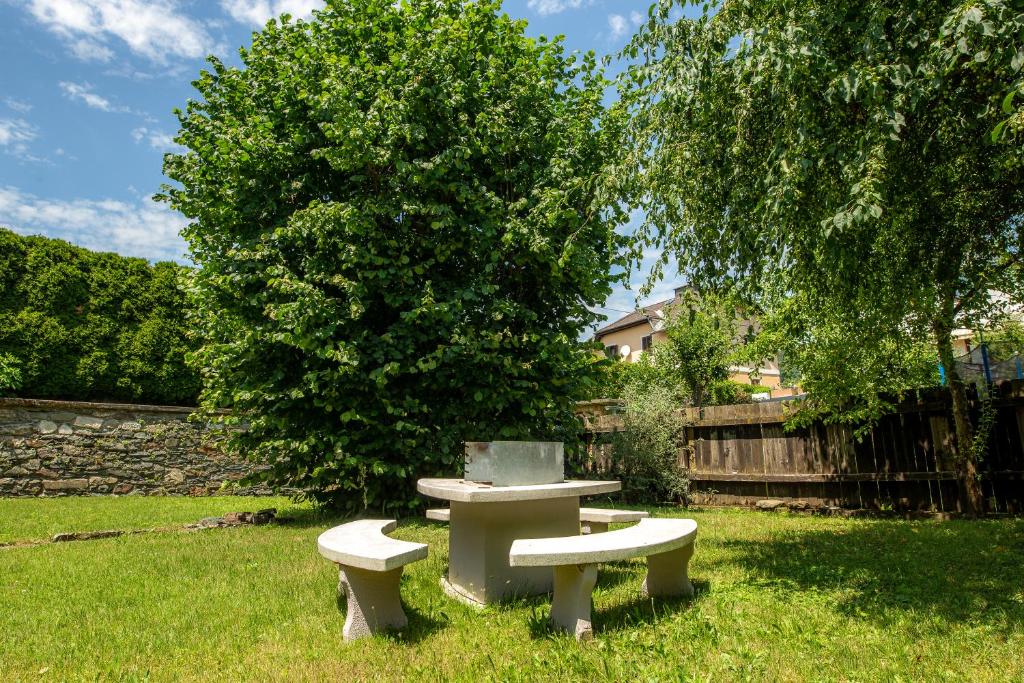 einen Picknicktisch und zwei Bänke im Hof in der Unterkunft L&P Appartement Klagenfurt in Klagenfurt am Wörthersee