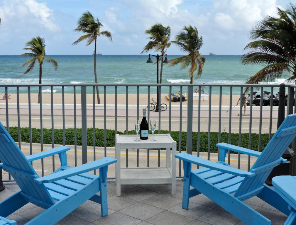 a bottle of wine on a table with two chairs and the beach at Snooze in Fort Lauderdale