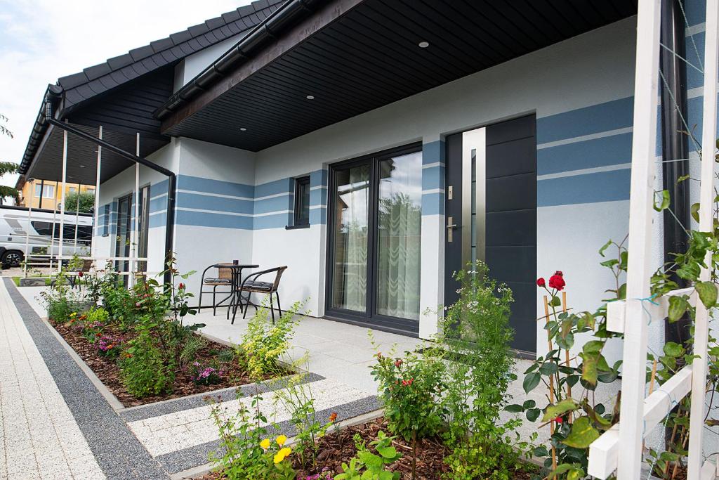 a house with blue and white stripes on it at DOMKI RELAX in Rewal