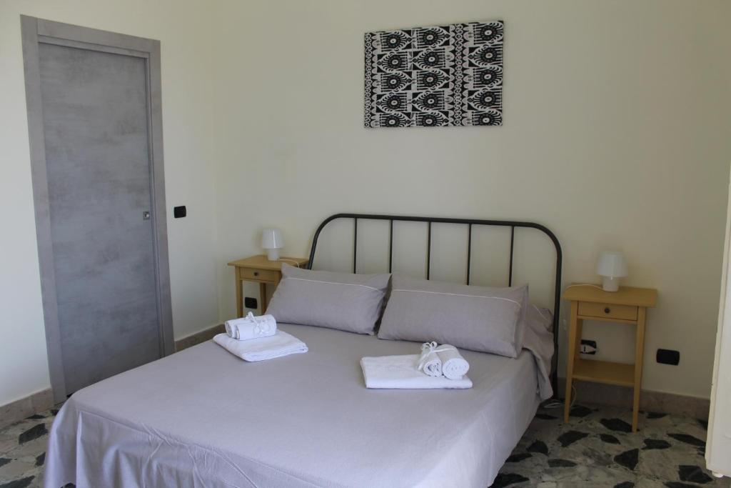 a bedroom with a bed with two towels on it at Casa Vistosa Agrigento in Agrigento