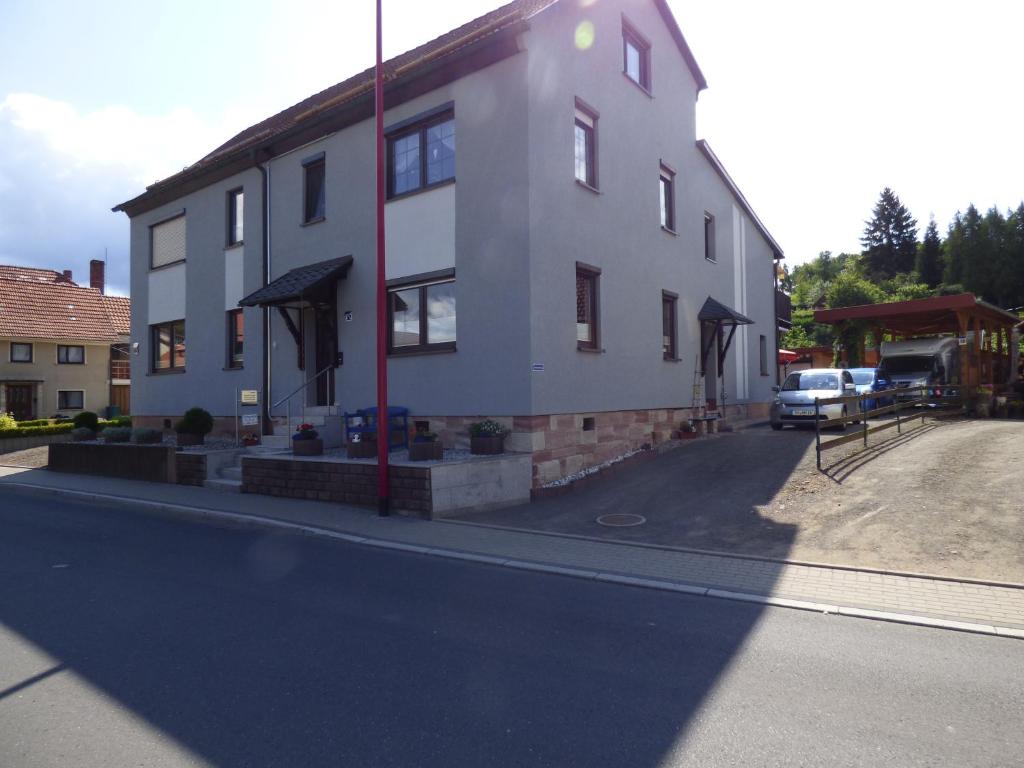 ein weißes Gebäude an der Straßenseite in der Unterkunft Ferienwohnung Fräbel in Asbach