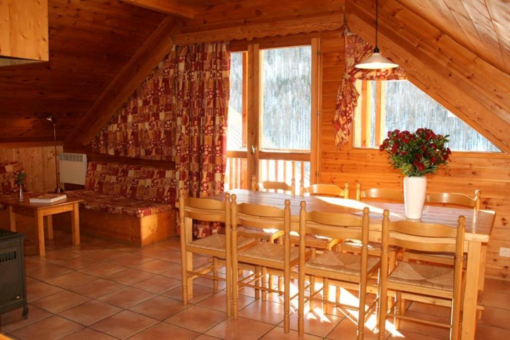 a dining room with a table and chairs in a cabin at Le Sorè Hameau des Chazals Nevache Hautes Alpes in Névache