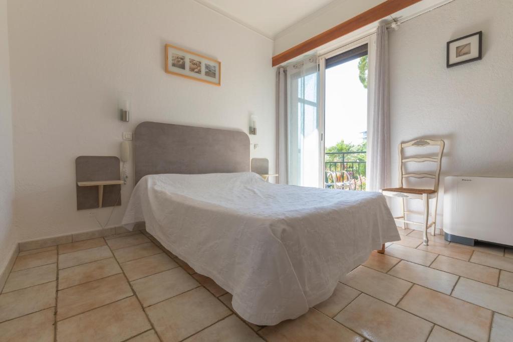 Postel nebo postele na pokoji v ubytování Hôtel Les Alizés