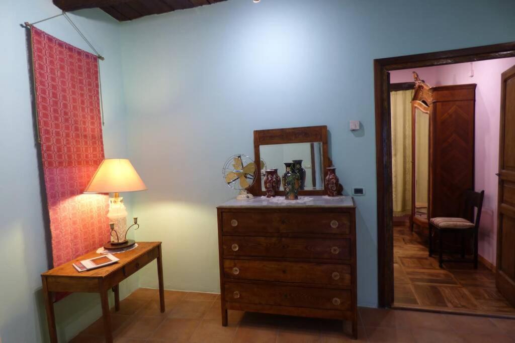 ein Schlafzimmer mit einer Kommode, einem Spiegel und einer Lampe in der Unterkunft Il Nibbio - La Casa del Vasaio in Morano Calabro