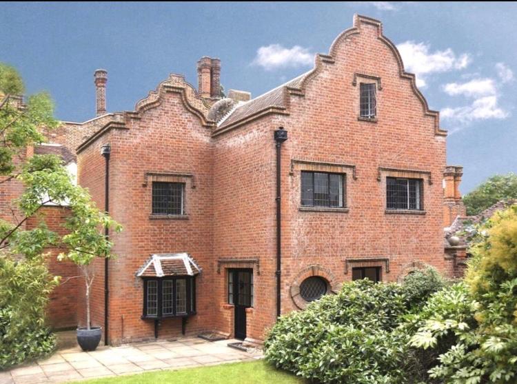 a large red brick building with a window at Luxury 3 Bed House on the Estate of 17th Century Manor House in Colchester