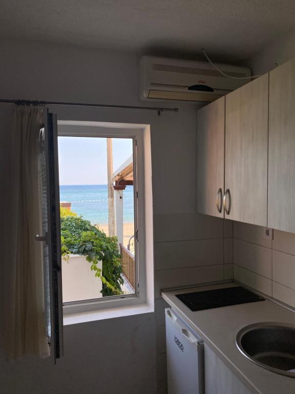 a kitchen with a window with a view of the ocean at Apartments Boss in Budva