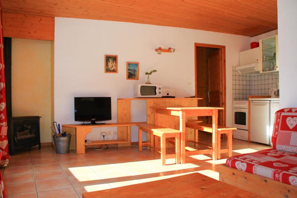a living room with a table and a kitchen at Le Taquo Hameau des Chazals Nevache Hautes Alpes in Névache