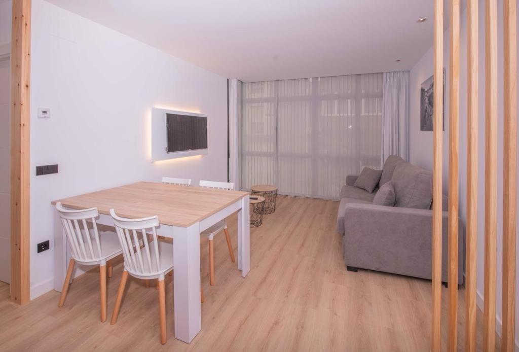 a living room with a table and a couch at APARTAMENTOS LLAMIEVA in Posada de Llanes