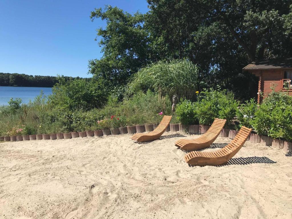 três cadeiras na areia numa praia em Haus am See Altjuehrden em Varel