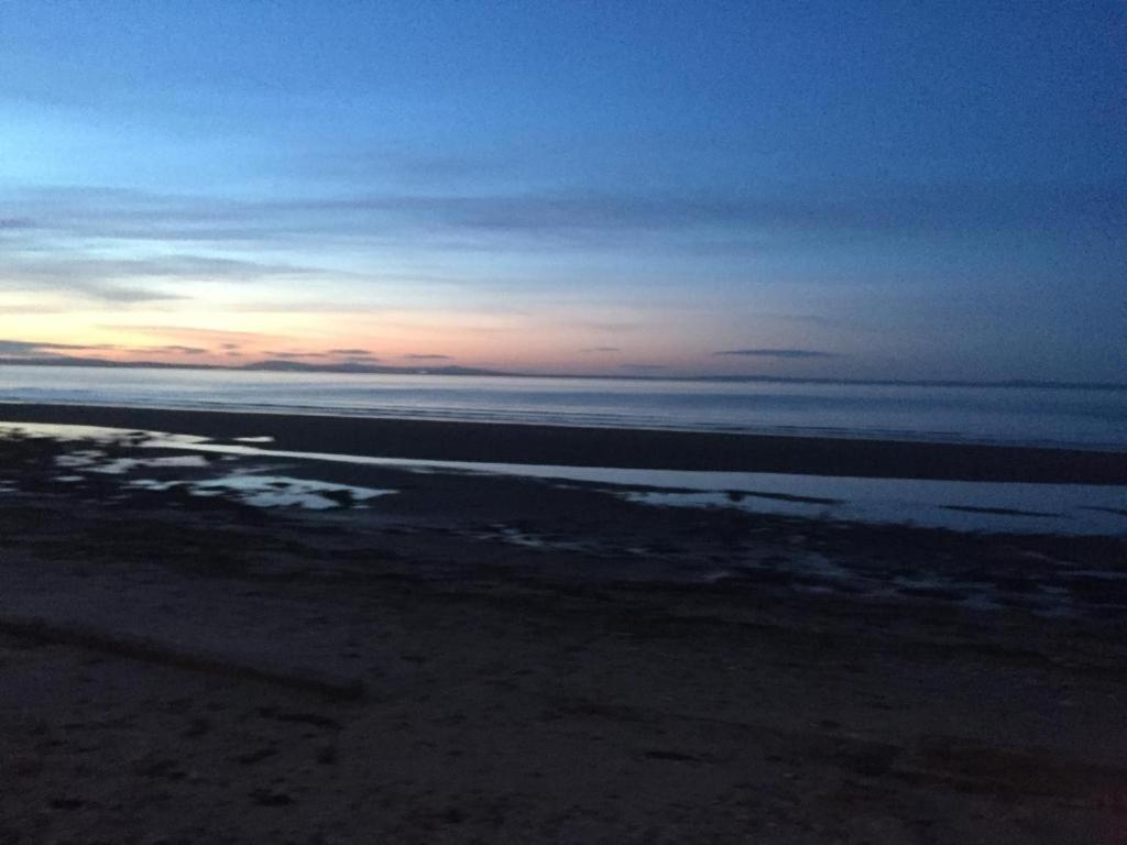 a view of the beach at sunset with the ocean at Magnificent sea view lodge in Port Seton