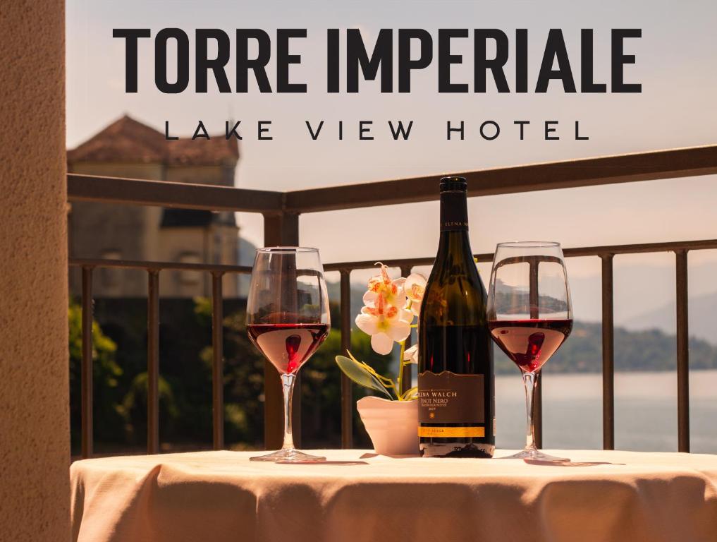 a table with two glasses of wine and a bottle at Hotel Torre Imperiale in Maccagno Superiore