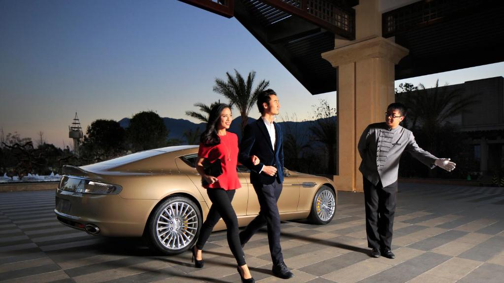 un grupo de tres personas de pie delante de un coche en InterContinental Kunming by IHG, en Kunming