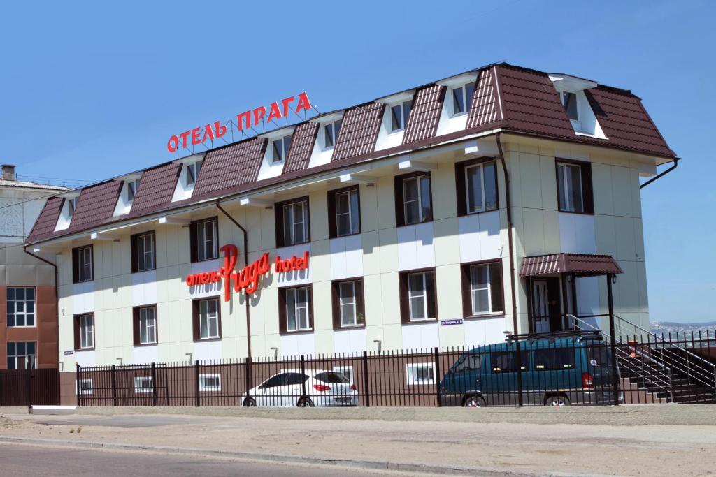 a building with cars parked in front of it at Praga Hotel in Ulan-Ude