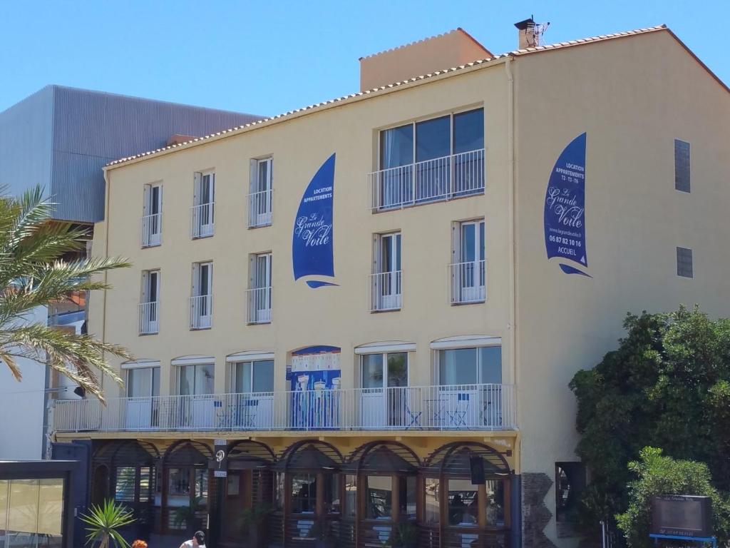 a building with blue signs on the side of it at Résidence La Grande Voile in Banyuls-sur-Mer