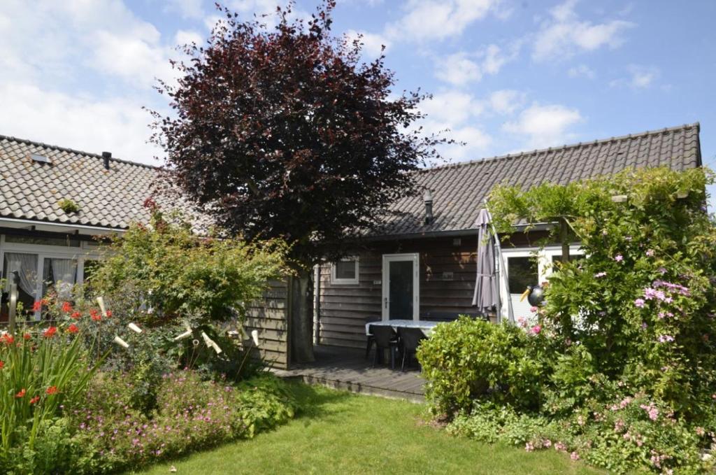 een klein huis met een tafel in de tuin bij Vakantiehuis Merel in Den Helder