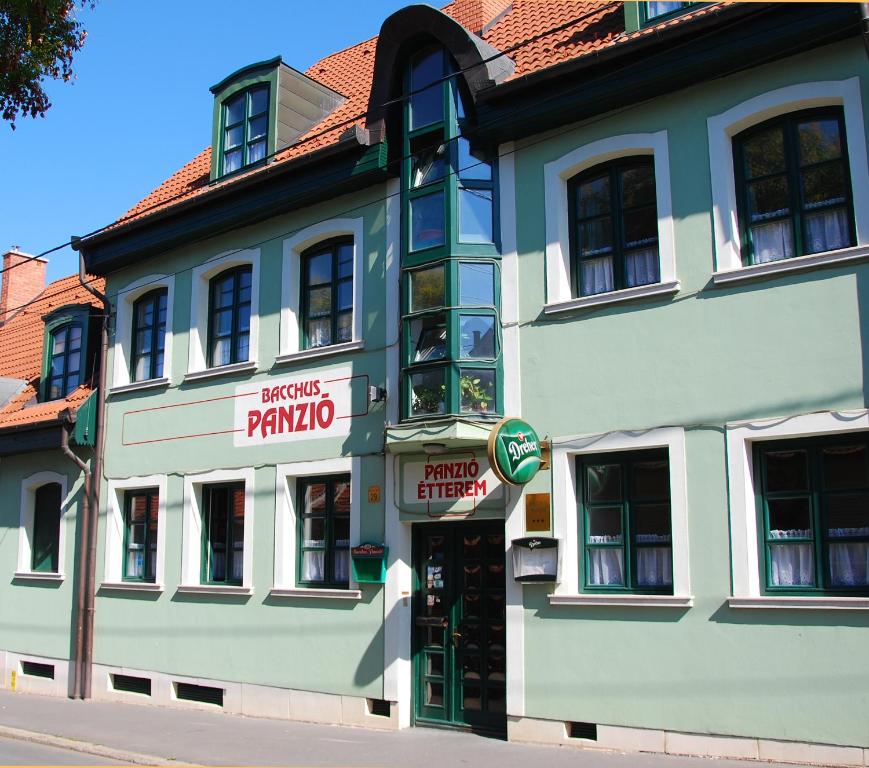 a large white building on the side of a street at Bacchus Panzió in Eger