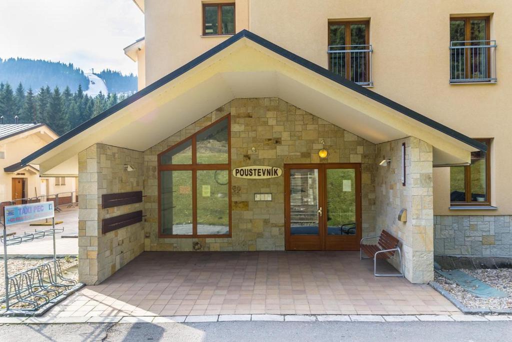 a building with a door with a sign on it at Apartmány Poustevník Resort in Pec pod Sněžkou